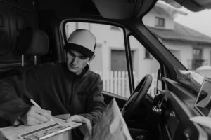 Fahrer dokumentiert eine Lieferung im Führerhaus eines Transporters